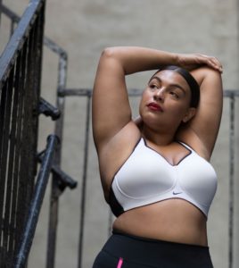 modelka Paloma Elsesser stoi w sportowym stroju na tle industrialnych betonów. Prezentuje stanik i leginsy z linii Nike+
